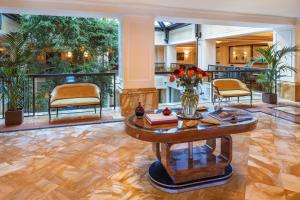 a living room with a table with a vase of flowers at Starhotels Du Parc in Parma