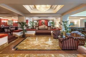 a living room with couches and a chandelier at Starhotels Du Parc in Parma +112 photos