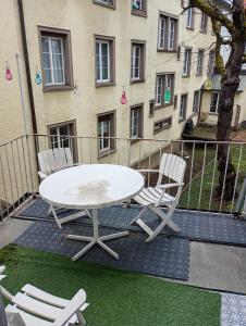 a white table and chairs in front of a building at Central tiny studio in St. Gallen