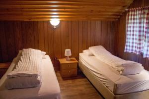 a bedroom with two beds and a table with a lamp at Old Cottage - Reynivellir II in Gerdi