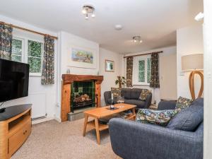 a living room with two couches and a fireplace at Orchard Cottage in Dawlish