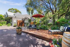 a house with a wooden deck with a red umbrella at Rosewood Guesthouse in Margaret River Town