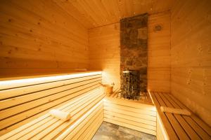 an empty wooden sauna with a stove in it at Boutique Hotel & Apartments Pension Sternen in Todtmoos