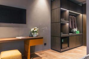 a room with a desk with a tv and a closet at Lenel Boutique Room - La Locanda in Brescia