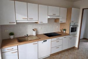 a kitchen with white cabinets and a sink at Domaine du Riadoux in Bonneuil