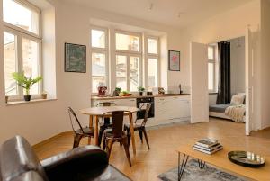 a living room with a table and a kitchen at Apartament na Granicy 6 in Cieszyn