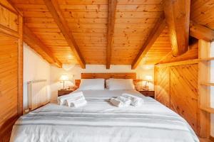 a bedroom with a large bed in a wooden ceiling at Rifugio del Sole Apartment in Monclassico