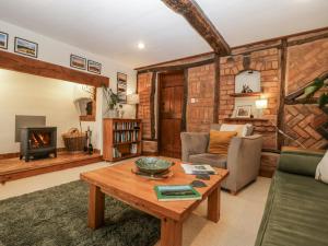 a living room with a table and a fireplace at Magpie Cottage in Worcester