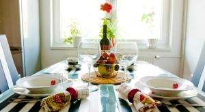 un tavolo con bicchieri da vino e un cesto di frutta di Apartman Šestine a Zagabria