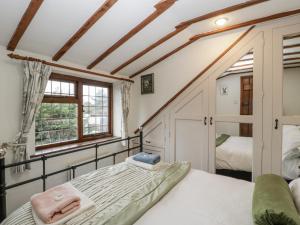 a bedroom with a bed and a window at Magpie Cottage in Worcester