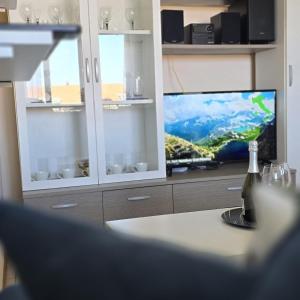 a living room with a tv and a bottle of wine at Anna in Cavallino-Treporti