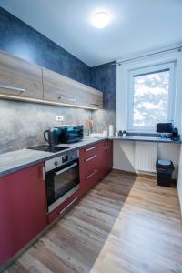 a kitchen with red cabinets and a window at Apartmán Tady 67 in Dolní Moravice