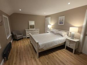a bedroom with a bed and two lamps and a chair at Annies Farm Cottage in Derry Londonderry