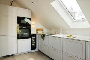a kitchen with white cabinets and a skylight at VILLA BRATTHOLMEN in Brattholmen
