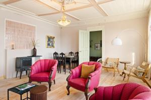 a living room with pink chairs and a table at VILLA BRATTHOLMEN in Brattholmen