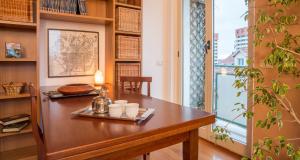einen Tisch in einem Zimmer mit Fenster in der Unterkunft ALTIDO Warm Family Flat for 6 with Terrace in Milan in Mailand