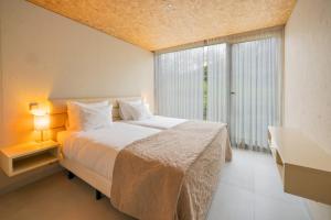a bedroom with a large bed and a large window at Paraíso Villas & Spa in Guimarães