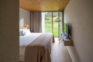 a hotel room with a bed and a window at Paraíso Villas & Spa in Guimarães