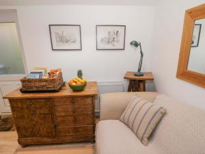 a living room with a couch and a table with a basket of fruit at Tucked Away in Evesham