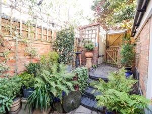 a garden with plants and a brick wall at Tucked Away in Evesham