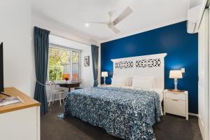 a blue bedroom with a bed and a desk at Rosewood Guesthouse in Margaret River Town