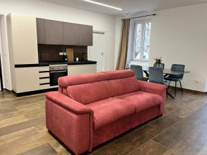 a living room with a red couch and a kitchen at Garibaldi 105 in Castrovillari