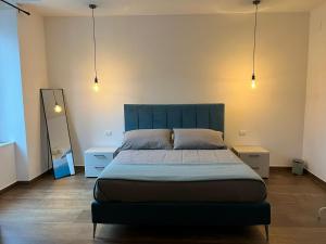 a bedroom with a large bed and two lights at Garibaldi 105 in Castrovillari