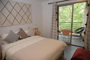 a bedroom with a bed and a sliding glass door at La Perle Ourika Valley Guest House in Ourika