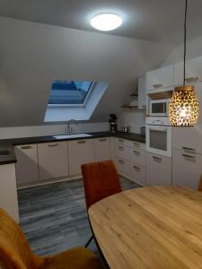 a kitchen with a wooden table and a dining room at Ferienhaus Höckelheim - FeWo Sternenhimmel - 100qm - 3 Schlafzimmer - bis 6 Gäste - Babies reisen gratis - Balkon, Garten & Grill - Klimaanlage, Raffstores & Fußbodenheizung - Smart-TV - Küche mit Induktionsherd & Spülmaschine - nahe Göttingen in Northeim