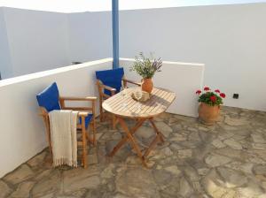 a table and two chairs and a table with flowers at Andros Guesthouses in Andros