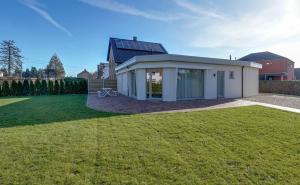 a small white house with a large yard at 't Vennehuys - vakantiehuis nabij Bokrijk in Genk