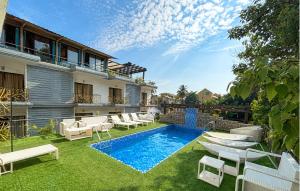 a backyard with a swimming pool and lounge chairs at Nitya Resort, Calangute in Calangute