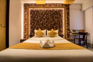 a bedroom with a large bed with two pillows at Hotel Malad Inn opposite Malad Railway Station in Mumbai