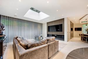 a living room with a large couch and a television at Luxurious subterranean mansion - 3 spectacular bedrooms in Altrincham