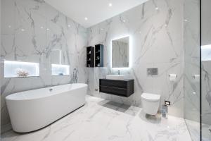 a white bathroom with a tub and a sink at Luxurious subterranean mansion - 3 spectacular bedrooms in Altrincham +24 photos