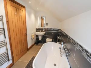 a bathroom with a bath tub and a sink at Chestnut Barn in Whitby +48 photos