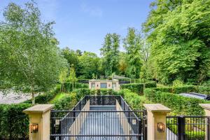 a gate to a house with a garden at Luxurious subterranean mansion - 3 spectacular bedrooms in Altrincham
