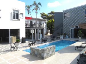 a courtyard with a pool and chairs and a building at Eden Hotel on Florida in Durban