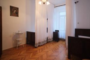 a living room with a wooden floor and a curtain at Samostan Mekinje in Kamnik