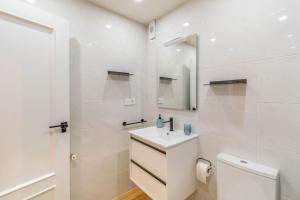 a white bathroom with a sink and a mirror at Espacioso y cómodo apartamento en Pamplona in Barañáin