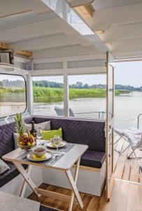 a dining area on a boat with a table at Neues Hausboot für 4 Personen Müritz und Plauer See in Lübz +8 photos