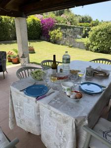 a table with a bottle of wine and plates of food at Home Nicola Jago in Castiadas