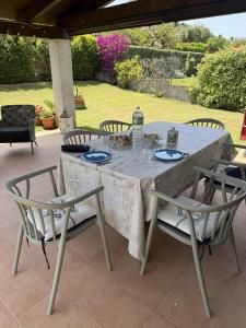 a table with chairs and a table with wine glasses at Home Nicola Jago in Castiadas +21 photos