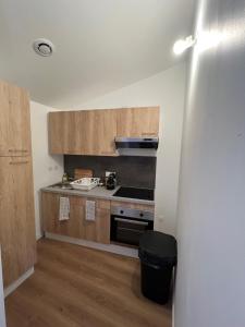 a kitchen with wooden cabinets and a stove top oven at Signature Apartment in Pélussin +2 photos