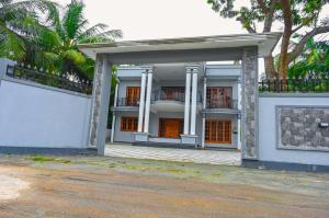a white house with a porch and a balcony at Rika Guest House in Kokkuvil East +2 photos