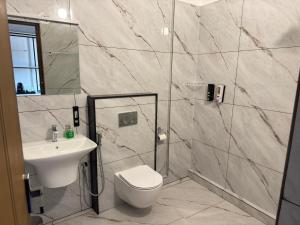 a bathroom with a sink and a toilet and a shower at Coorg Homes in Madikeri