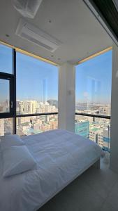a white bed in a room with large windows at SunU Seoul Stay - All Rooms 45m Panoramic Han River View - 4m Ceiling in Seoul