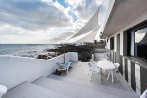 einen Balkon mit einem Tisch, Stühlen und Meerblick in der Unterkunft Villa Caracoles in Costa Teguise