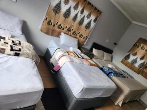 a small bedroom with two beds and a window at Matte Guest House in Potchefstroom