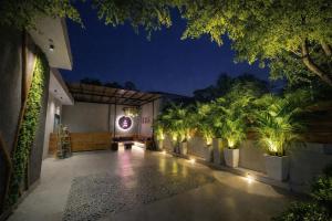 a courtyard with palm trees and lights at night at "Earthy Couple Retreat Near Taj Mahal" Private Spa Jacuzzi in Agra